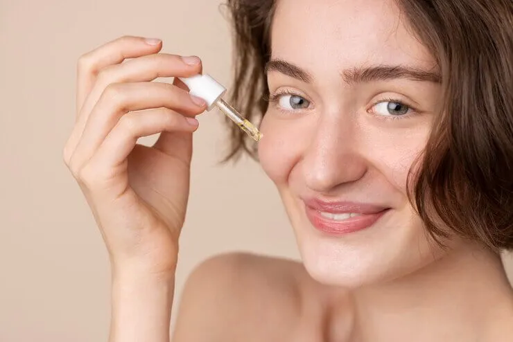 Women applying retinol serum